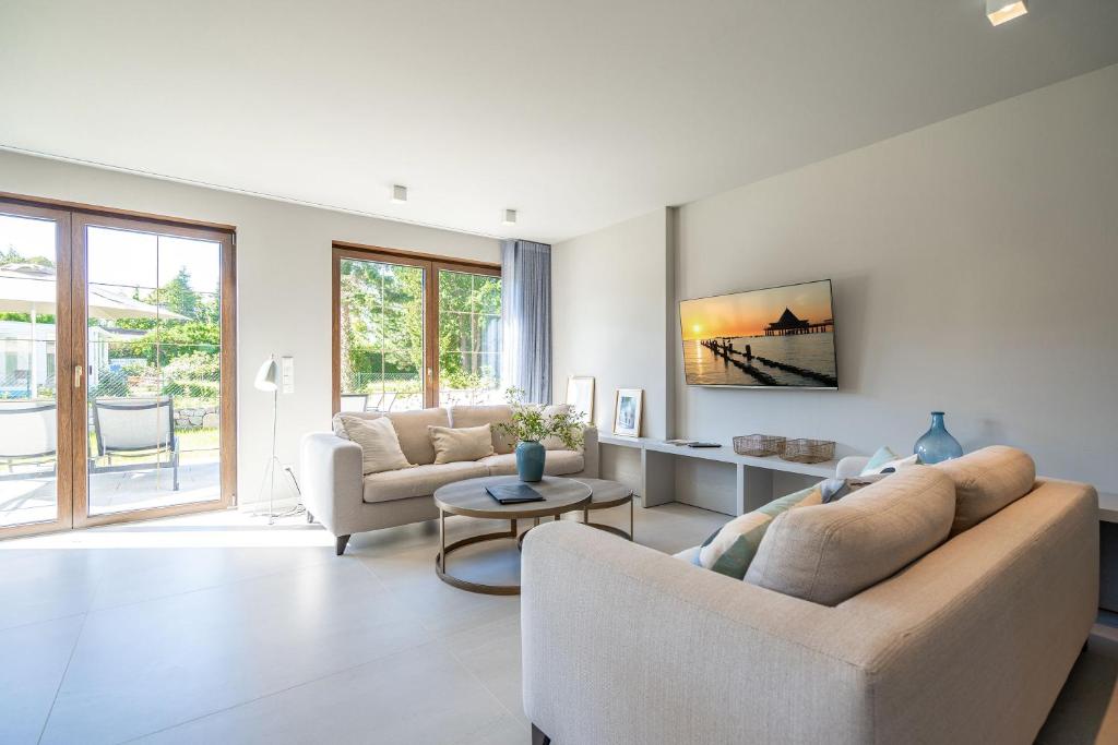 a living room with two couches and a table at Ferienhaus Reet & Meer N 2 in Bansin