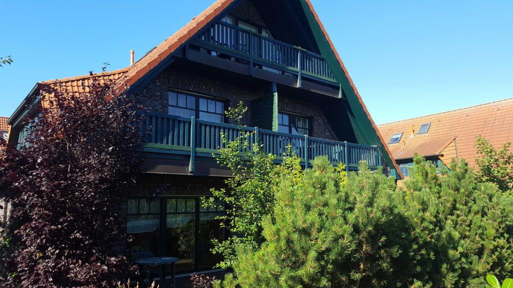 a building with a balcony on the side of it at Urlaubslust Ferienhaus 12 in Trassenheide