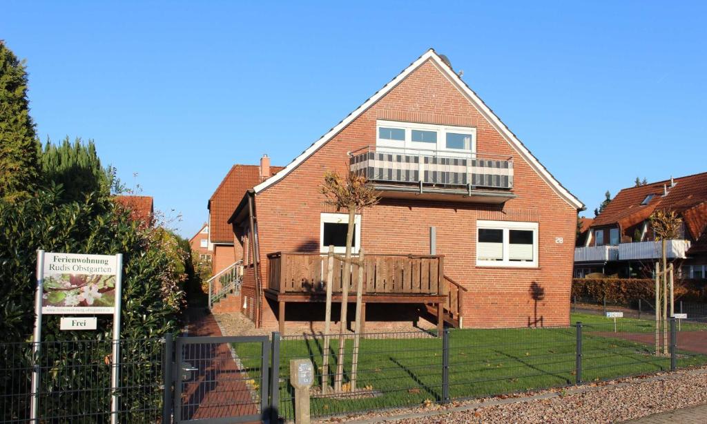 a brick house with a deck on the front of it at Ferienwohnung Rudis Obstgarten in Jork