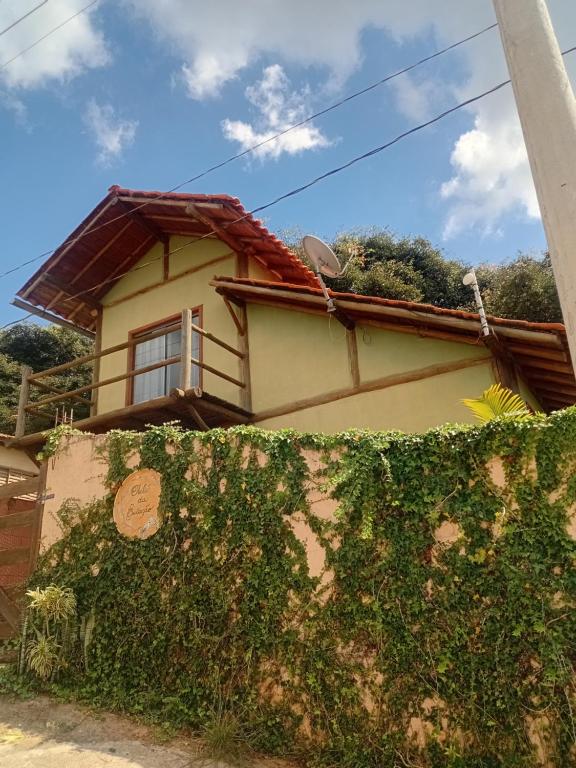 a house with a green hedge in front of it at Chalé da Estação in Carrancas