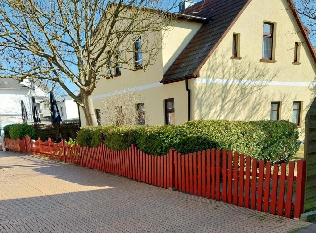 a red fence in front of a house at Rügen Fewo 31 in Göhren