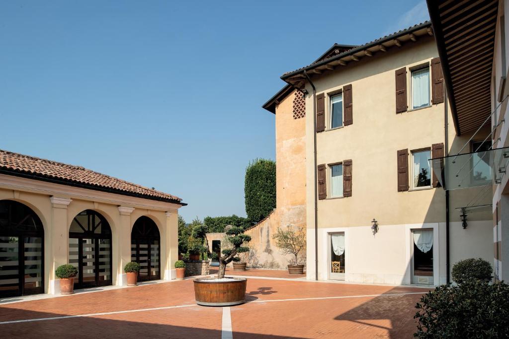 a courtyard between two buildings with a potted plant at Borgo Santa Giulia in Corte Franca