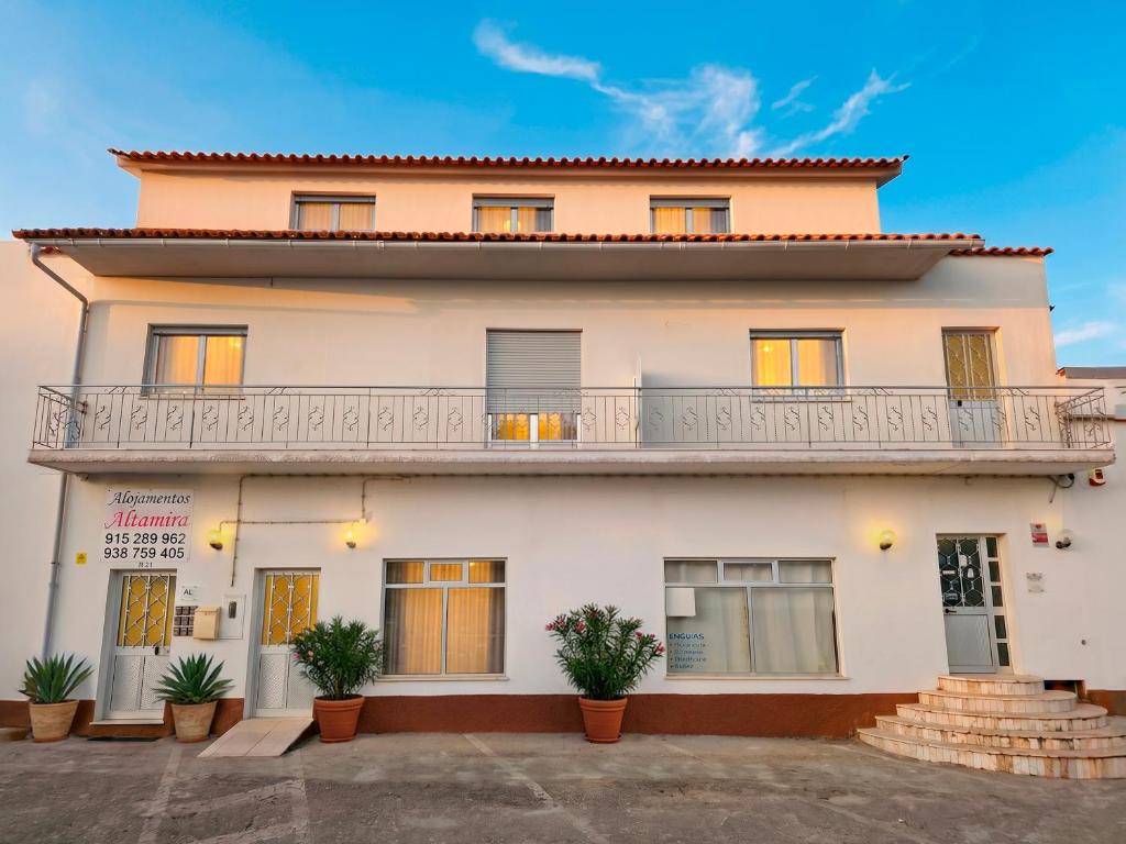 a large white building with a balcony at Alojamentos Altamira in Formigal