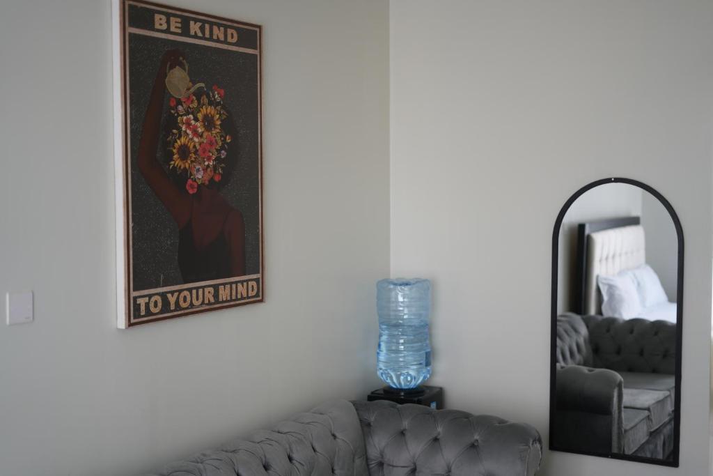 a living room with a couch and a mirror at Elite Escape in Muchatha