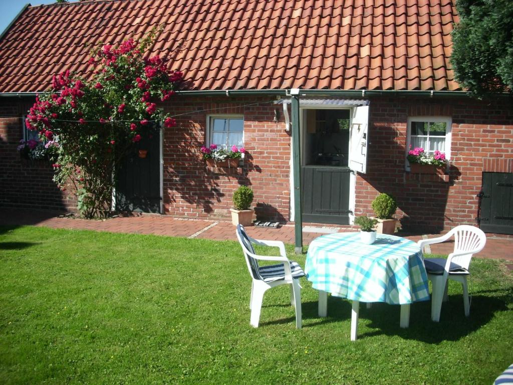 a table and chairs in the yard of a house at Ahlborns Bluetenhof in Jork
