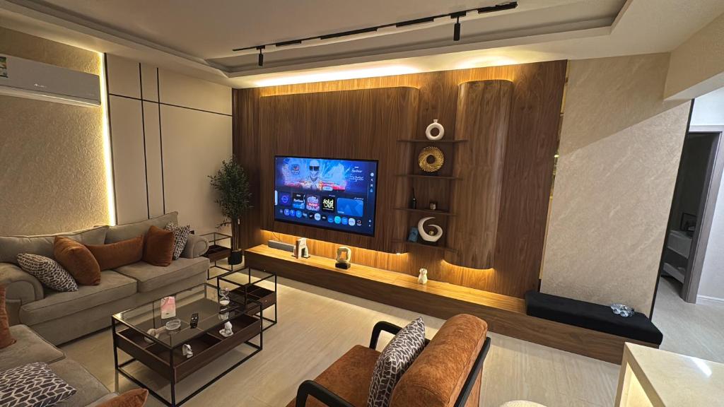 a living room with a couch and a tv at شقة مودرن مع جاكوزي خاص دخول ذاتي in Riyadh
