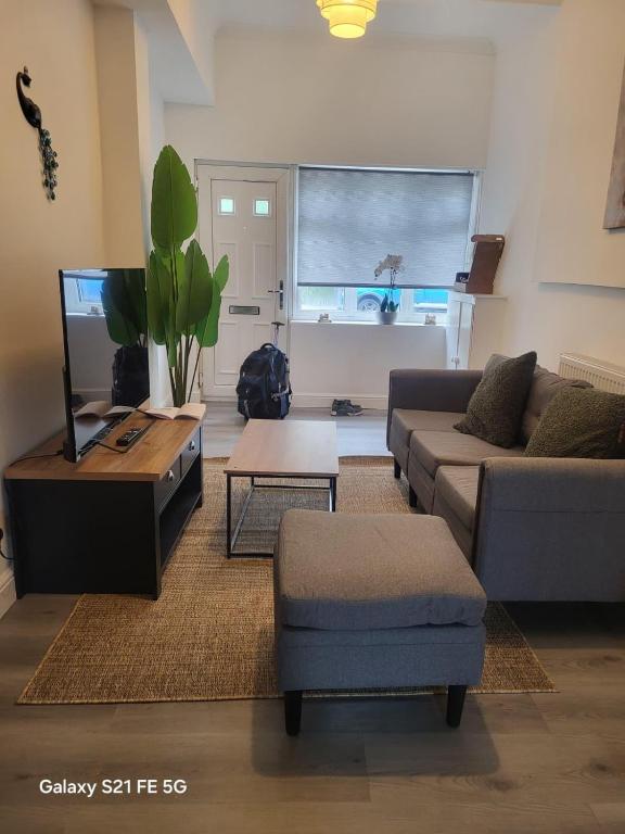 a living room with a couch and a tv at Perfectspot in Tilbury
