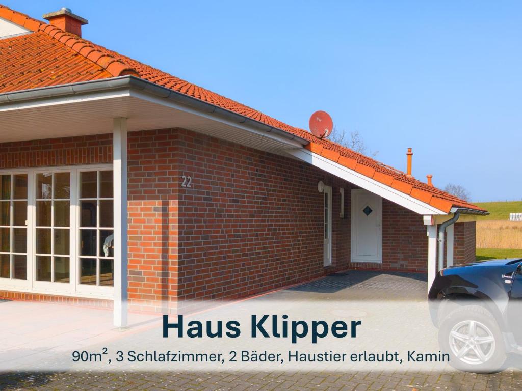 a brick house with a car parked in front of it at Haus Klipper - Nordseebad Burhave in Burhave