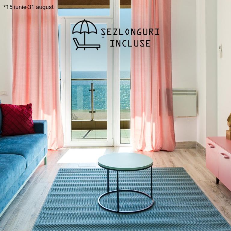 a living room with a blue couch and a table at Rezident Eforie Nord in Eforie Nord