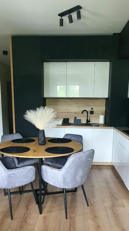 a kitchen with a table and some chairs and a counter at Mazury Home Apartament in Giżycko