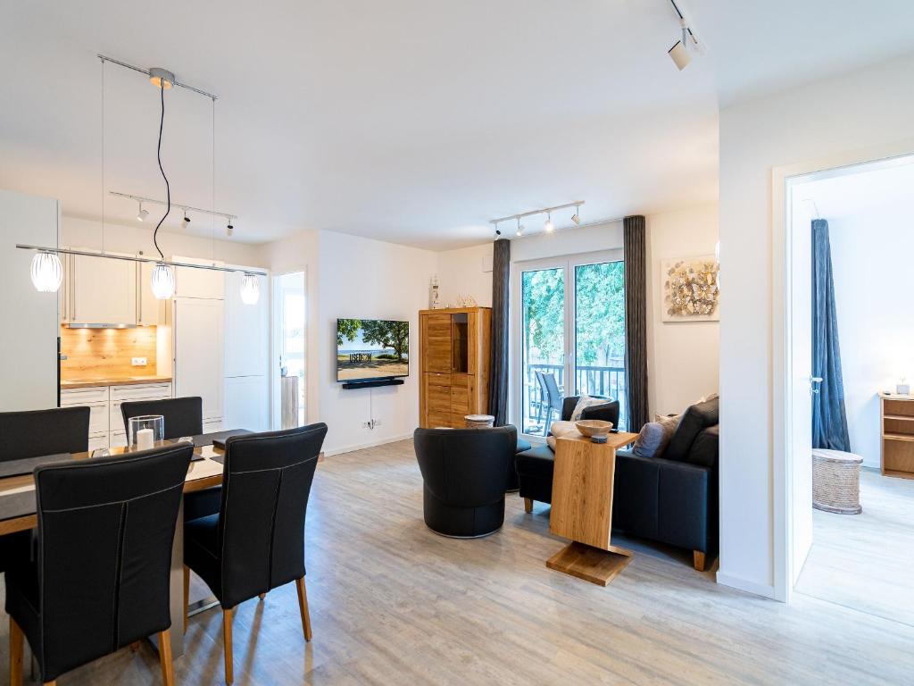 a living room and dining room with a table and chairs at Bernsteinquartier - Wohnung 87 in Kölpinsee