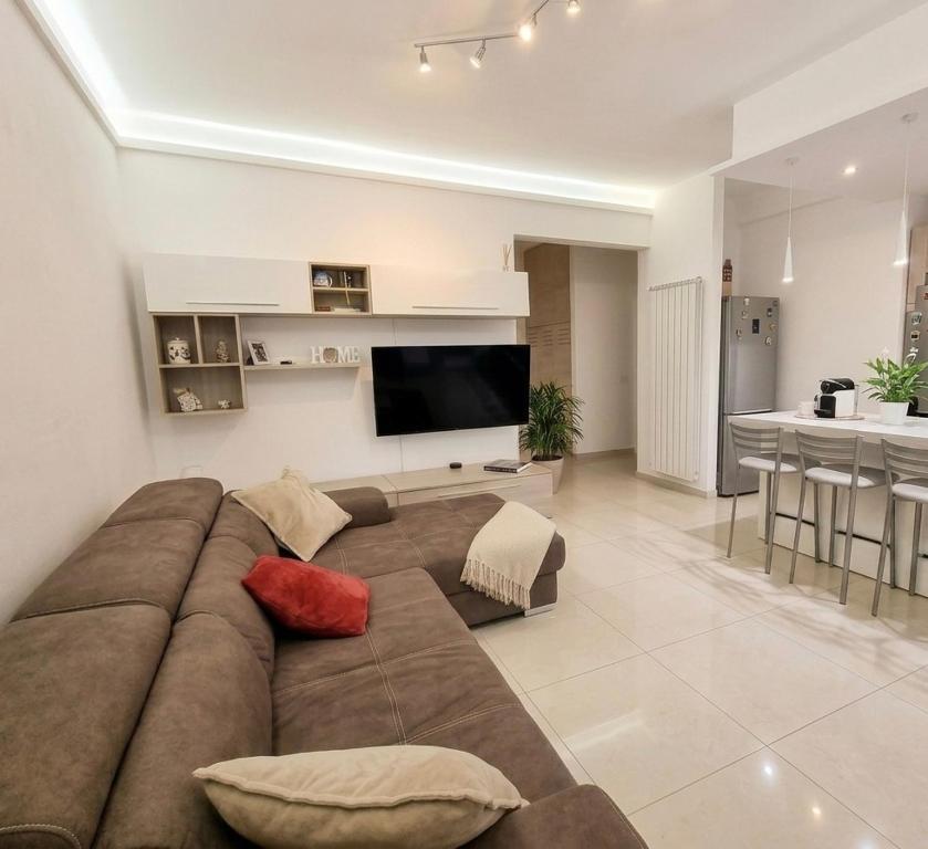 a living room with a large couch and a television at Aurora sul mare in Terracina