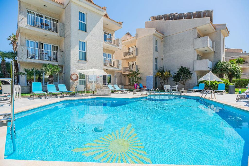 a large swimming pool in front of a building at Apartamentos Massol in Port de Pollensa
