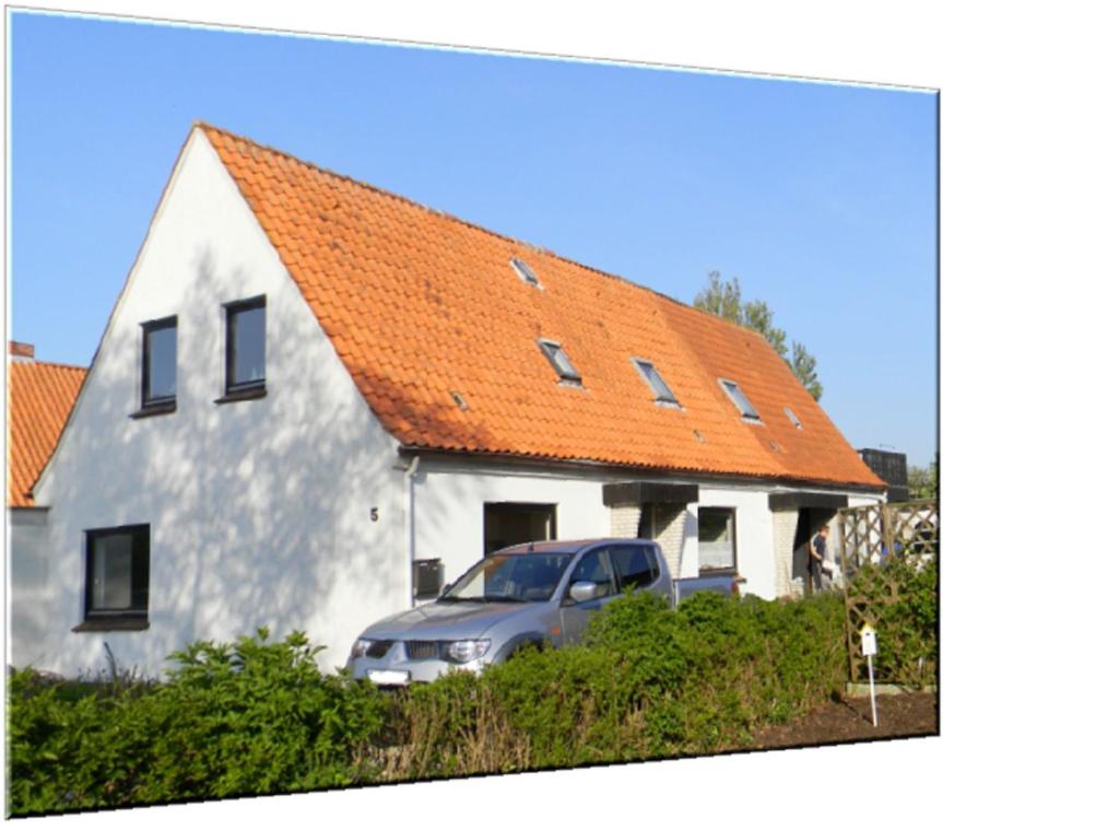 a van parked in front of a white house with an orange roof at Ferienwohnung Hilde Schneider in Kappeln