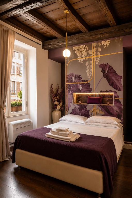 a bedroom with a large bed with a painting on the wall at Vicolo delle Belle Suite in Terracina