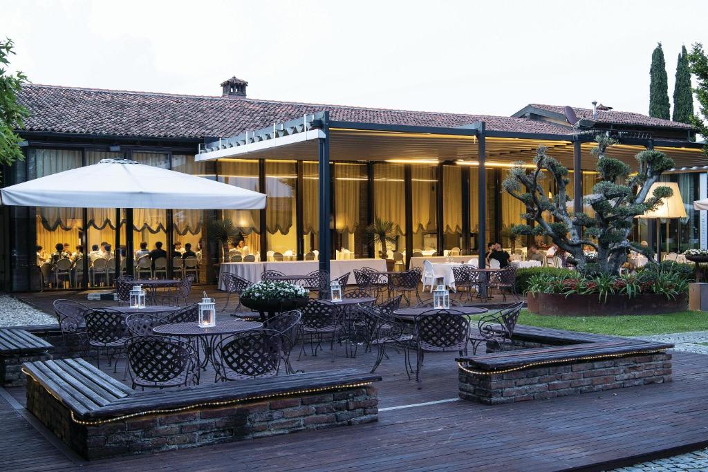 an outdoor patio with tables and chairs and a restaurant at La Colombera Ristorante - Albergo in Castrezatto