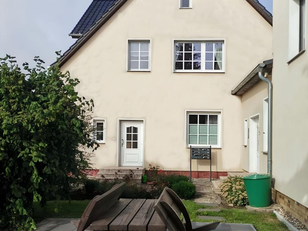 a white house with a wooden bench in front of it at Peene Alte Schule Völschow Dornberger in Völschow