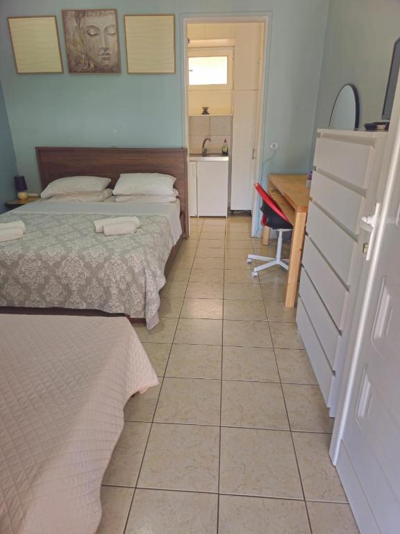 a room with two beds and a table and a desk at ΕΥΡΙΠΟΣ in Kritharia