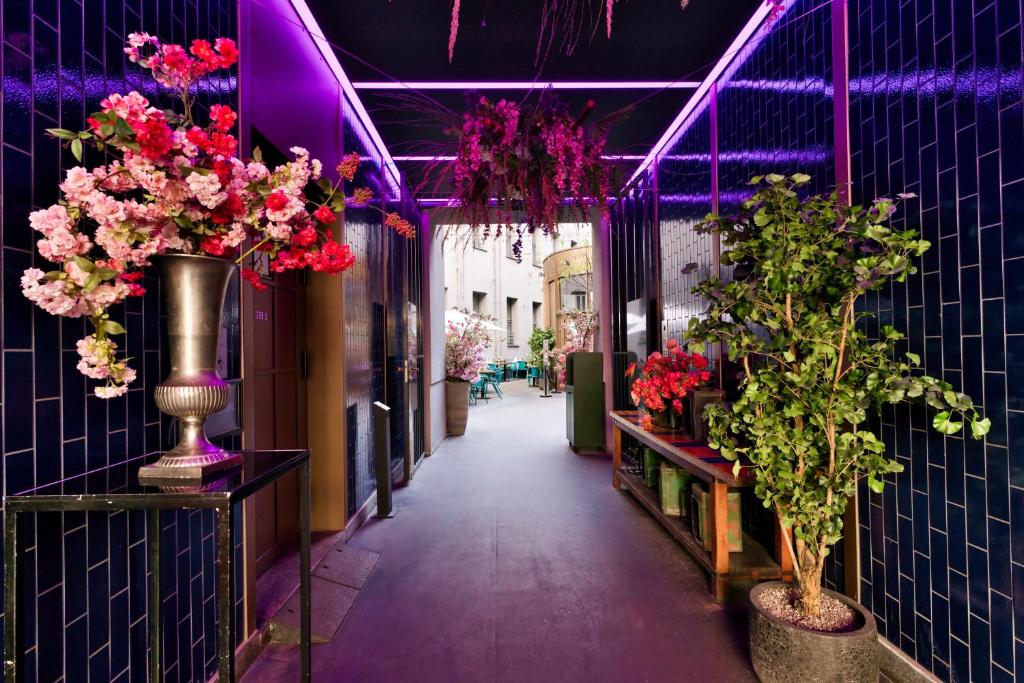 a corridor with vases of flowers and plants at AMO by AMANO Friedrichstrasse in Berlin