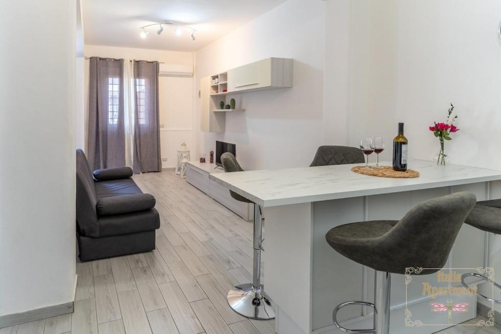 a kitchen and living room with a counter and chairs at Italia Apartment in Catania