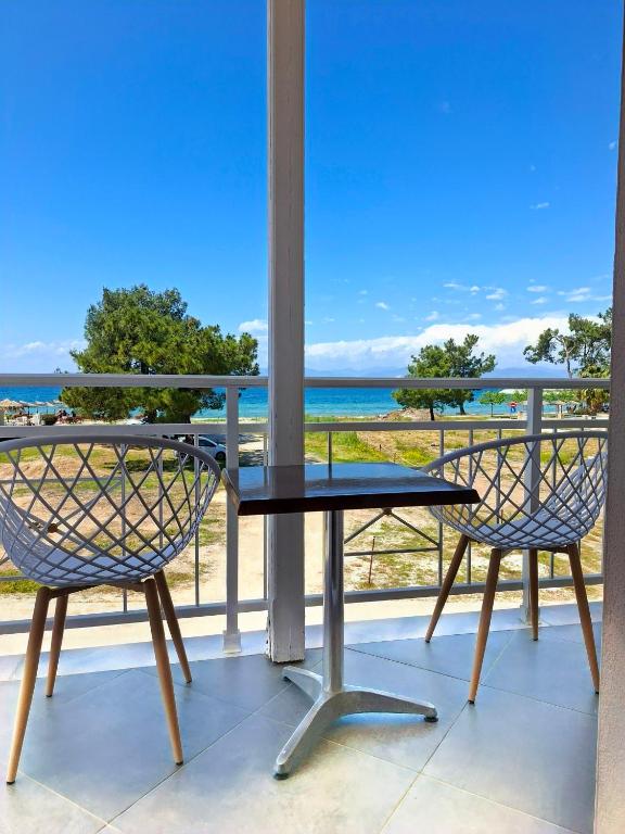 a table and two chairs on a balcony with the ocean at Studio Lazaridi in Skala Rachoniou