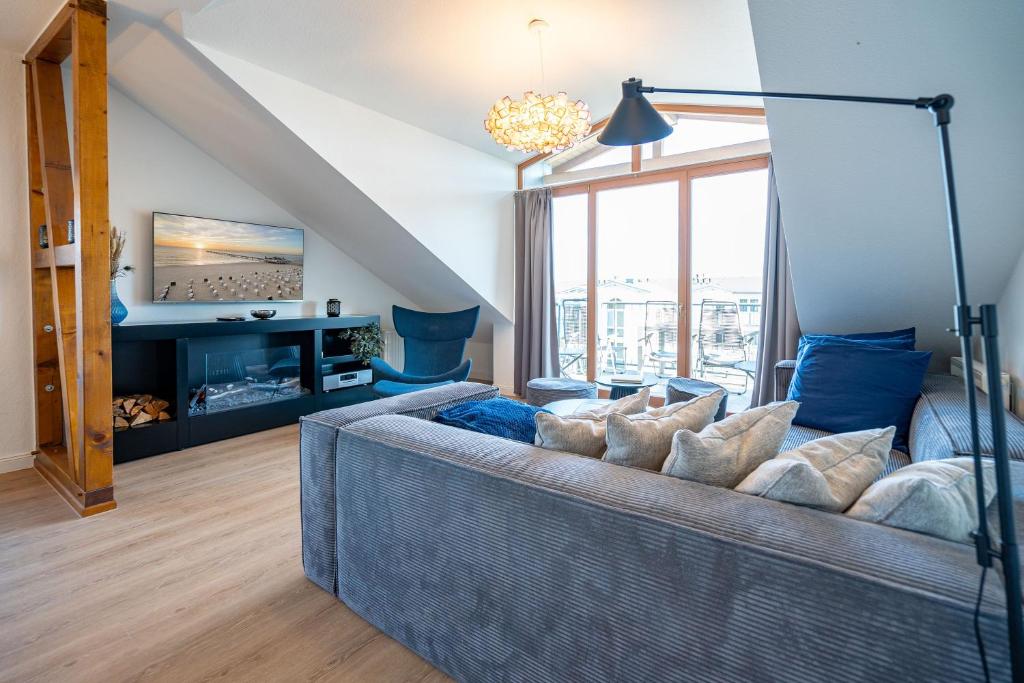 a living room with a blue couch and a tv at Villa Linquenda App 6 in Ahlbeck