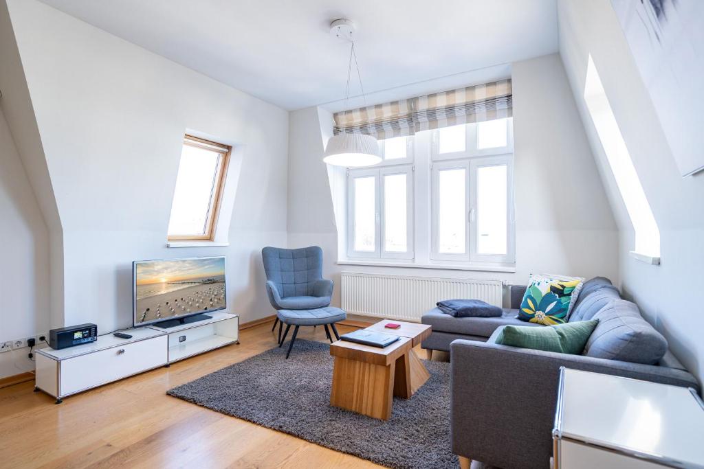 a living room with a couch and a tv at Schloss am Meer App 5 in Ahlbeck