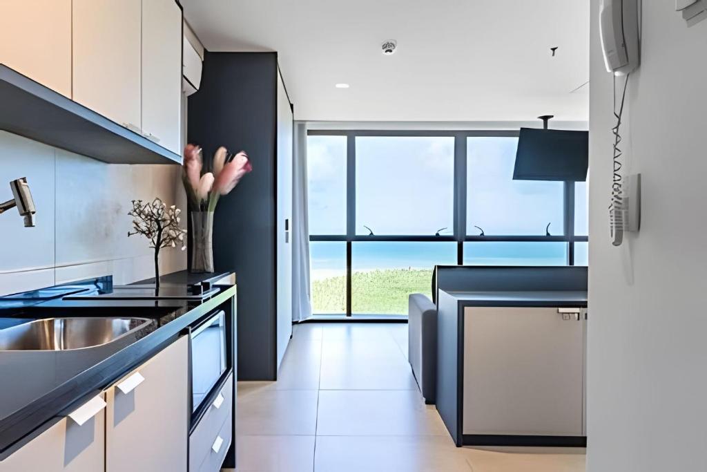 a kitchen with black and white cabinets and a sink at BHS Flat a beira mar 2203 in Recife