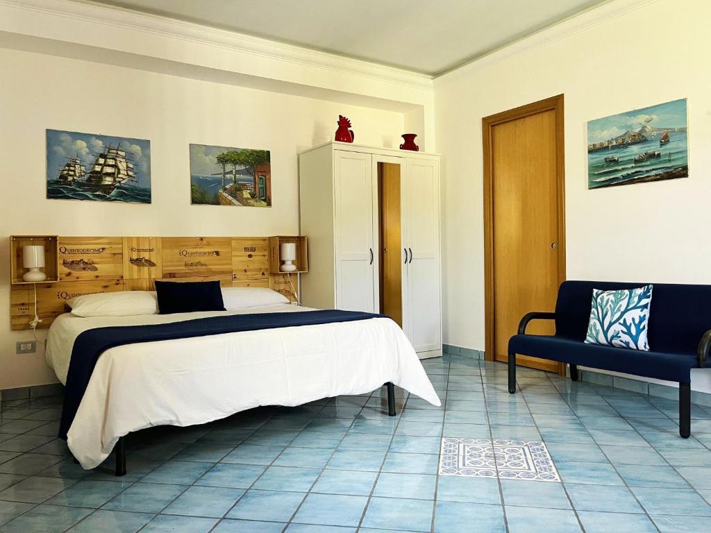 a bedroom with a bed and a blue chair at Casa Tasca in Ravello