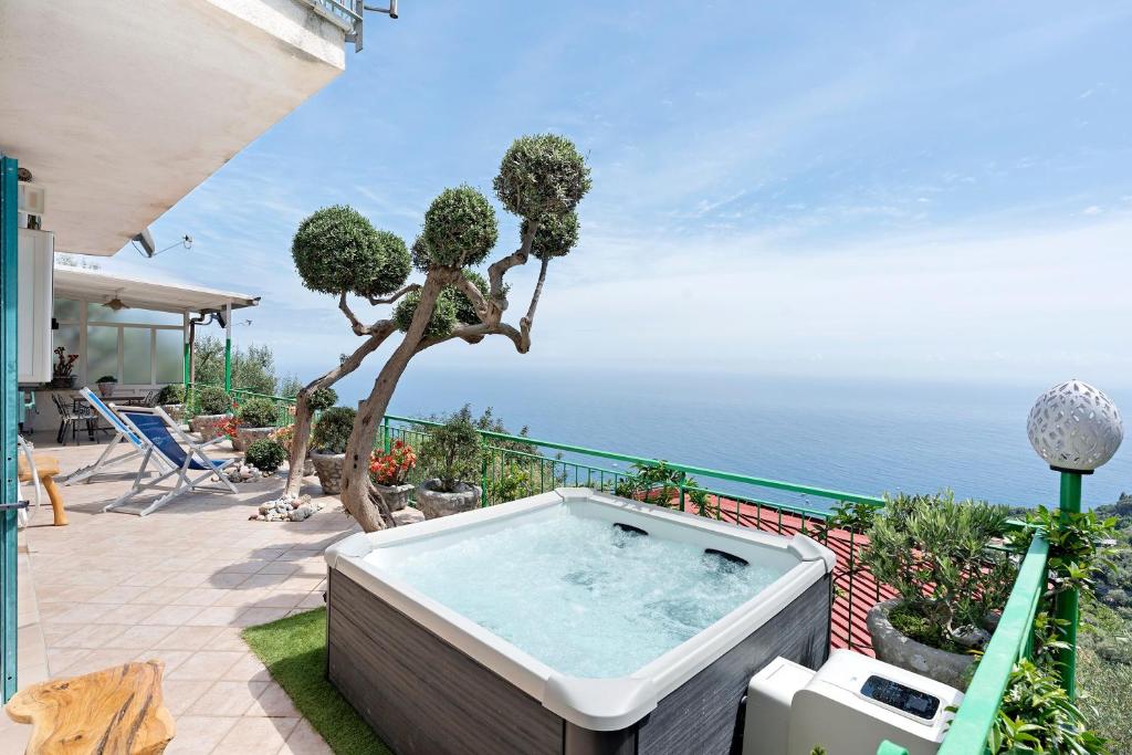 a hot tub on a patio with a view of the ocean at Ulivello House Sea View in Massa Lubrense