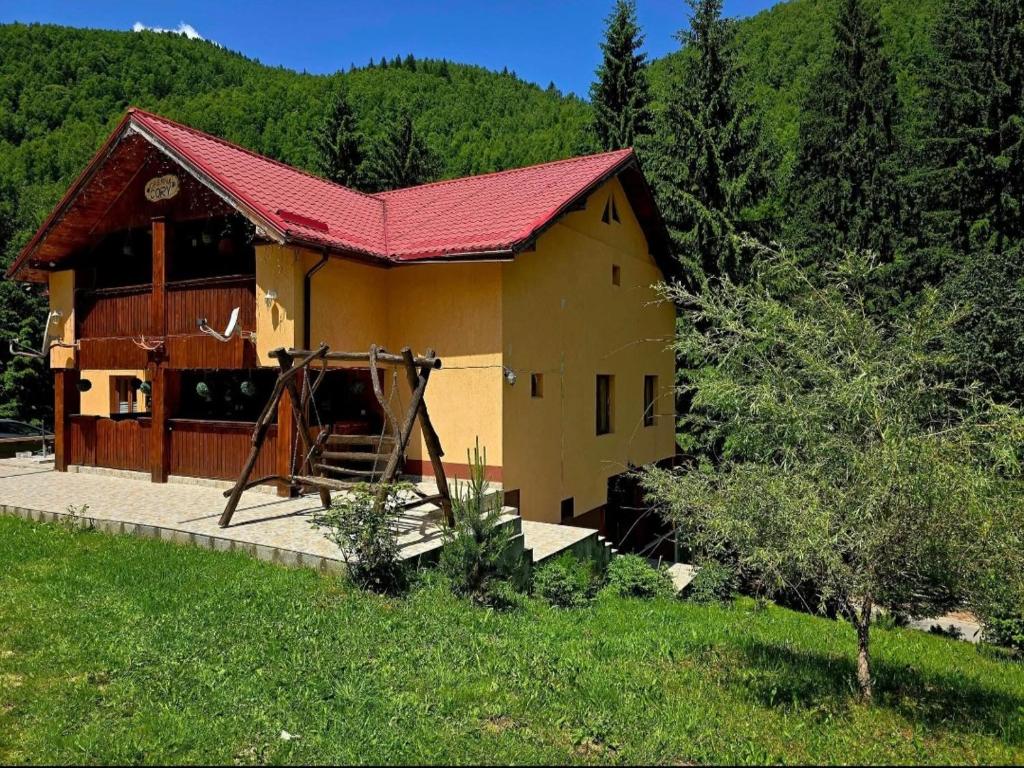 a small yellow house with a red roof at Cabana Cory Râușor in Râu de Mori