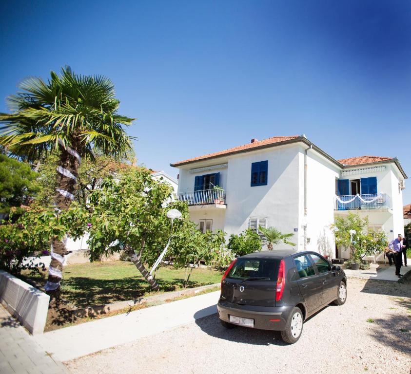 ein vor einem Haus geparktes Auto in der Unterkunft Morosini Apartments in Biograd na Moru