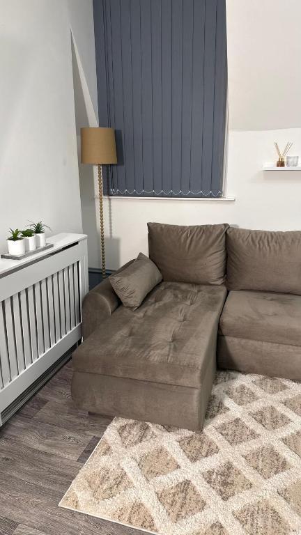 a living room with a brown couch in a room at Sheffield city centre apartment in Midland