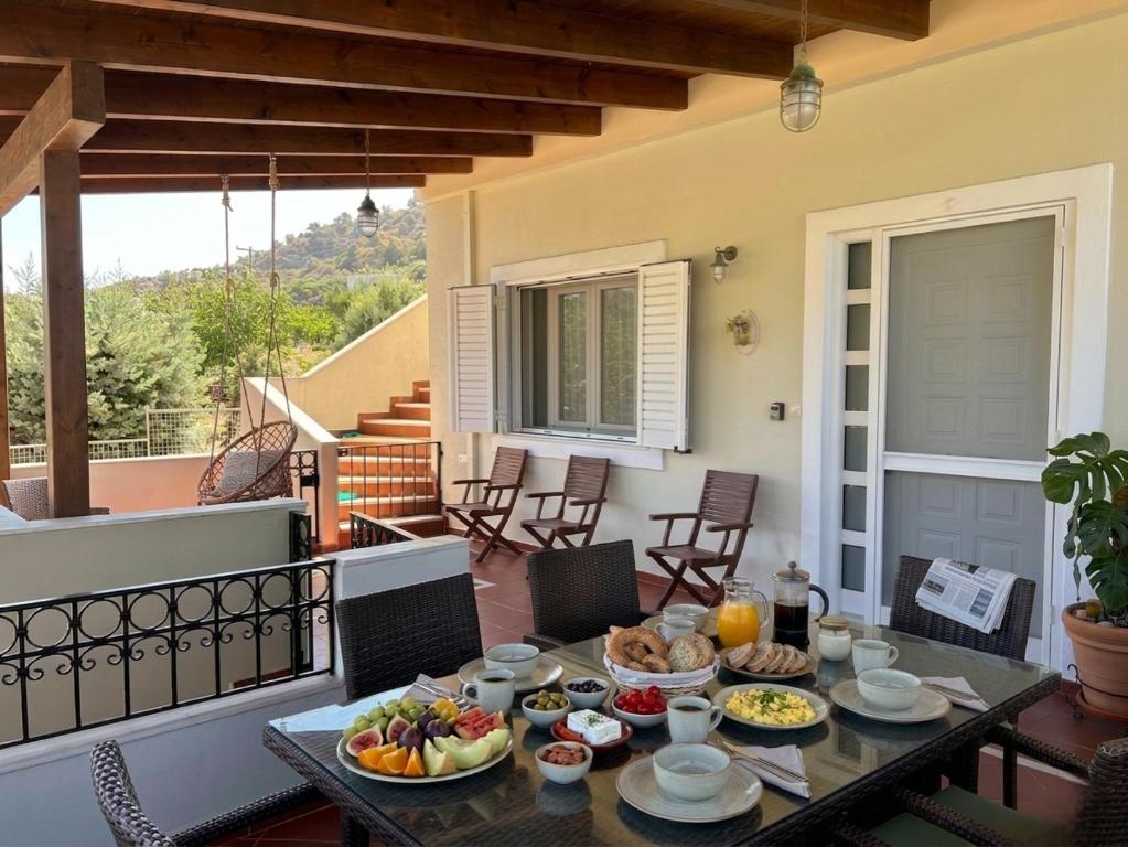 a table with plates of food on a patio at Verdalia Private Holiday House in Stavrákia