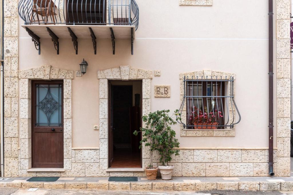 a facade of a house with two windows and a door at Bed and Breakfast San Domenico in Realmonte