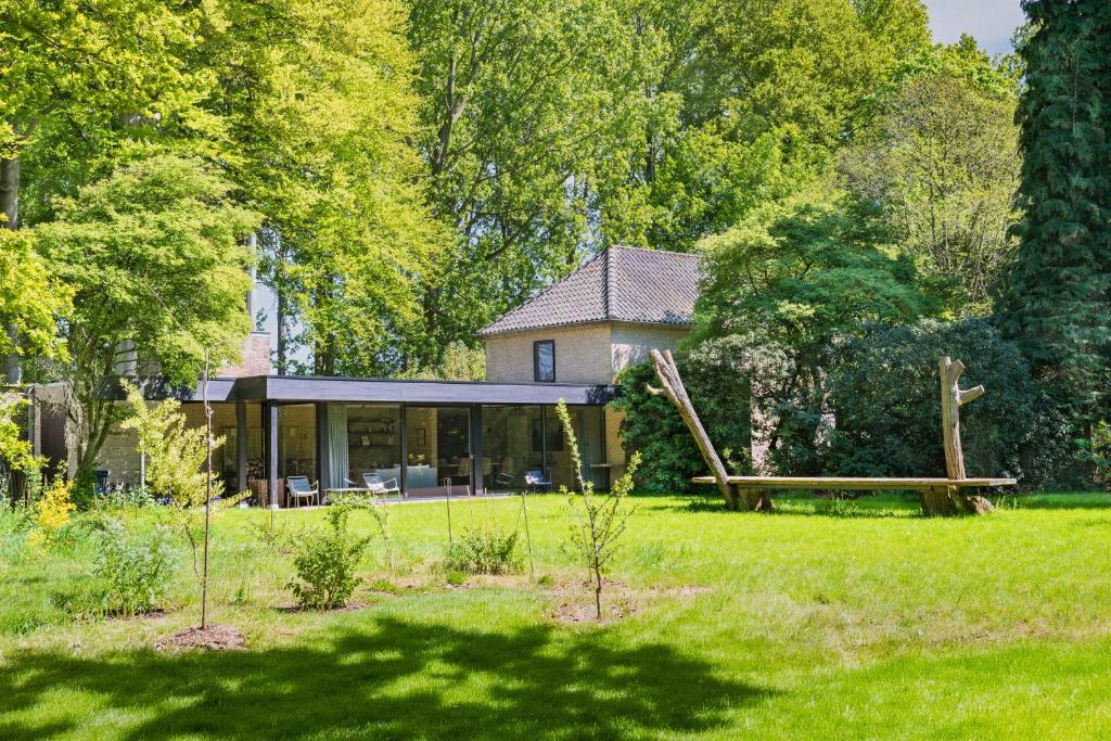 a house in the middle of a field with trees at B&B Hof Van Straeten in Jabbeke