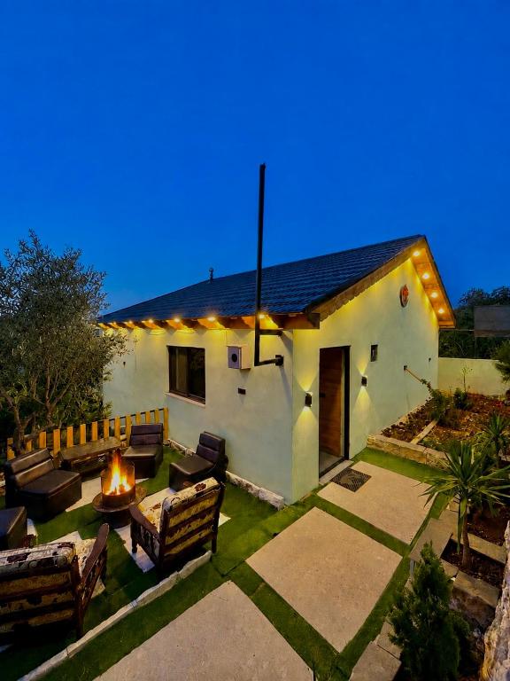 ein Haus mit einer Terrasse mit Feuerstelle in der Unterkunft Cherry farm in Adschlun