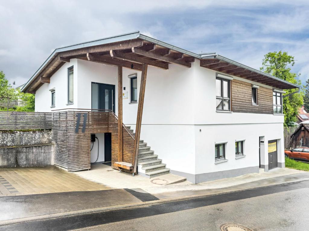 a white house with a wooden roof at Wohnplatz 52 in Inzigkofen