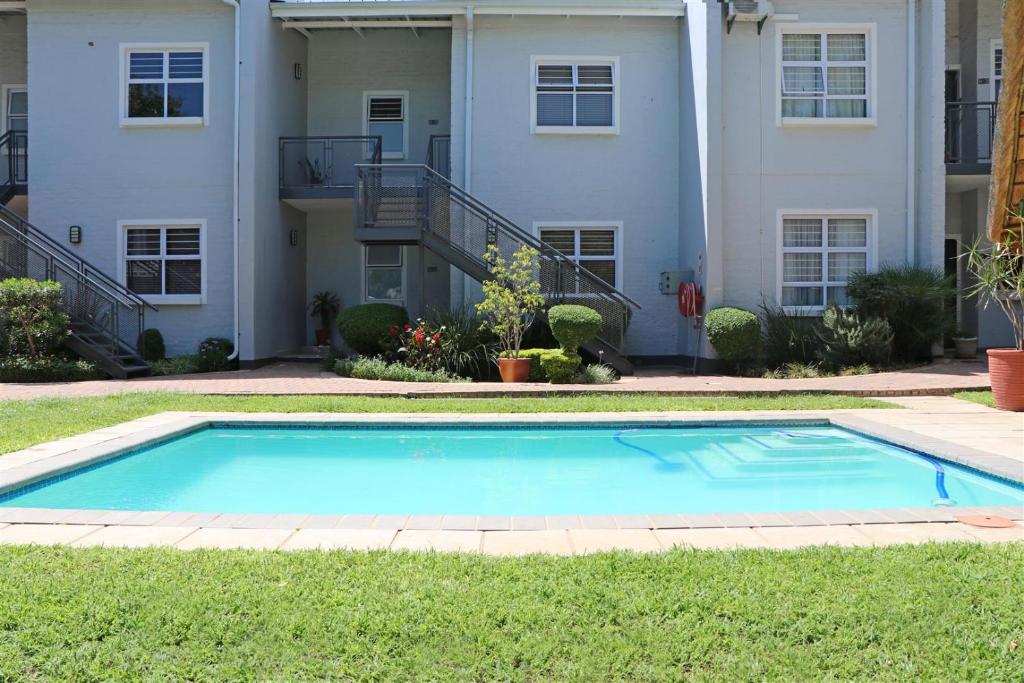 a swimming pool in front of a house at Apartments @ 125 in Gaborone
