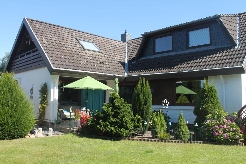 a house with a green roof and a yard at Thiessen - Ferienwohnung mit sonnigem Balkon in Silberstedt