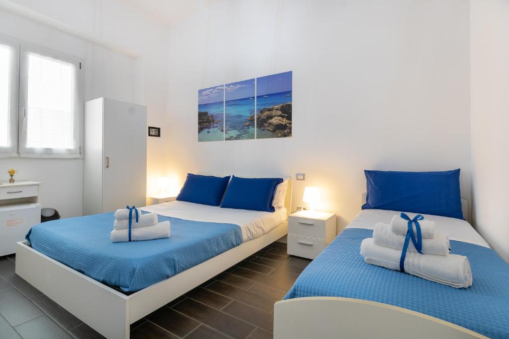 two beds in a bedroom with blue and white at Le Camere Di Anna in Gallipoli
