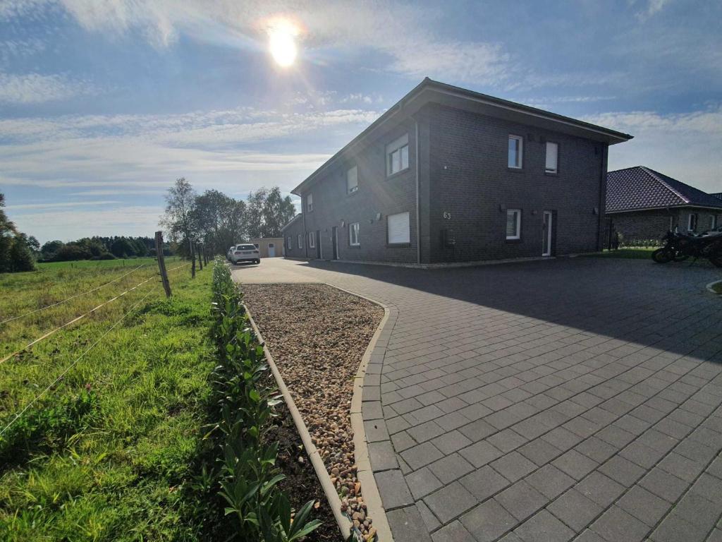 a large building with a driveway in front of it at Ferien am Idasee 85041 in Ostrhauderfehn