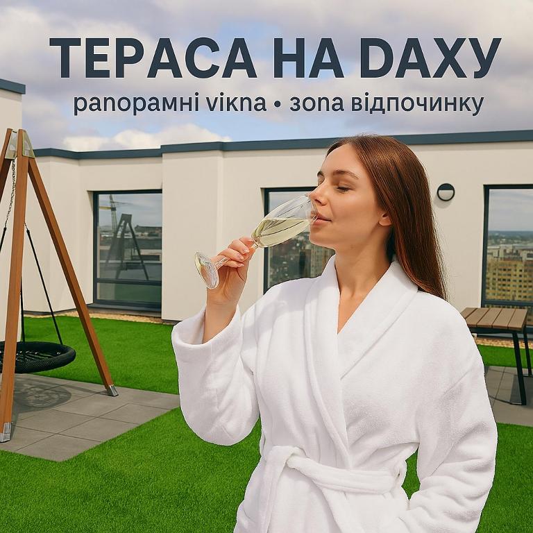 a woman in a white robe drinking a glass of wine at Зелена тераса in Lviv