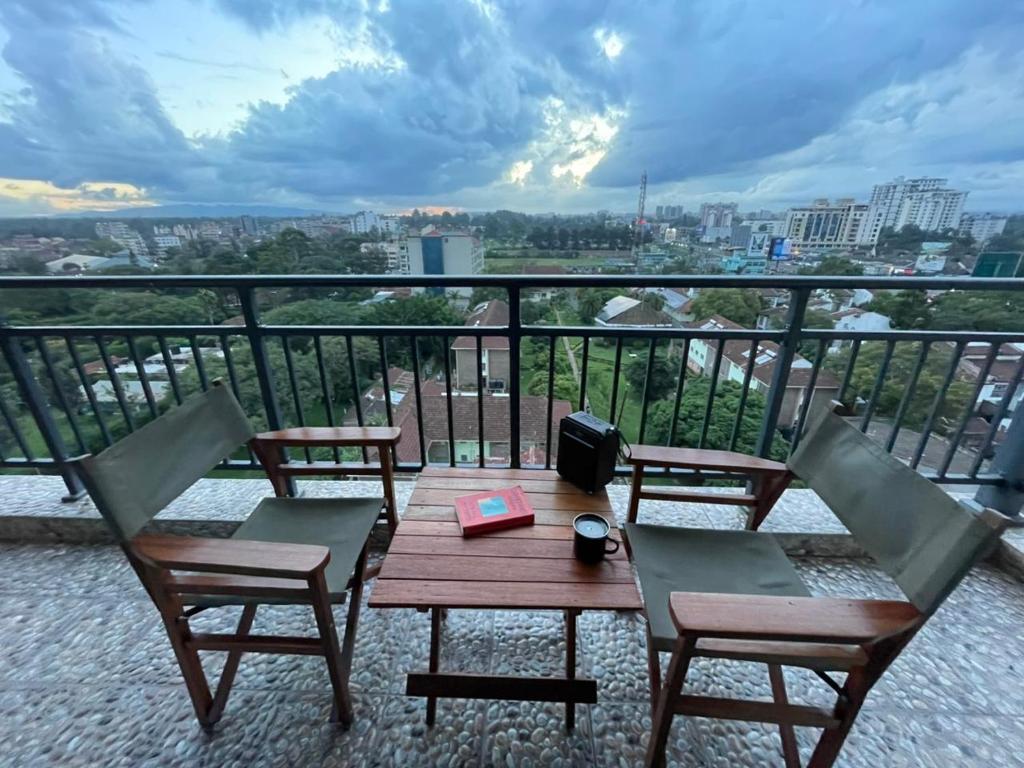 a table and chairs on a balcony with a view at Xenia Backpackers in Nairobi