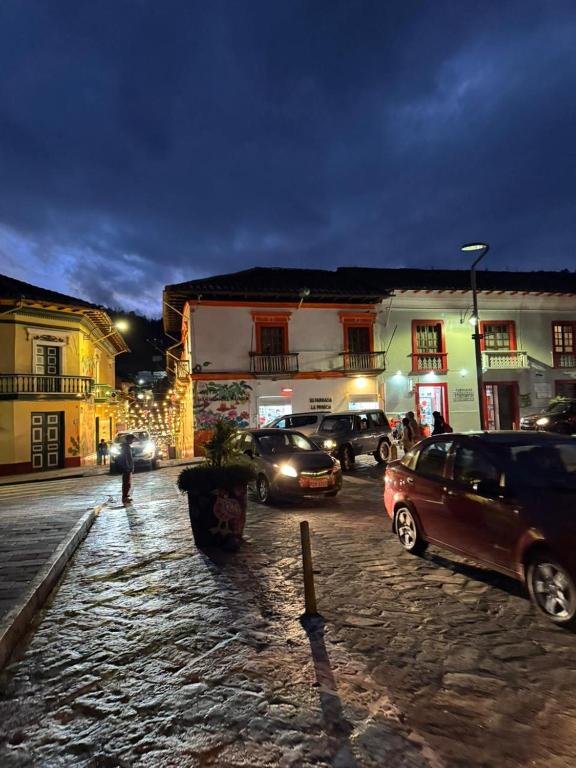 a group of cars parked on a street at night at Mansión del Parque by CS in Guaranda