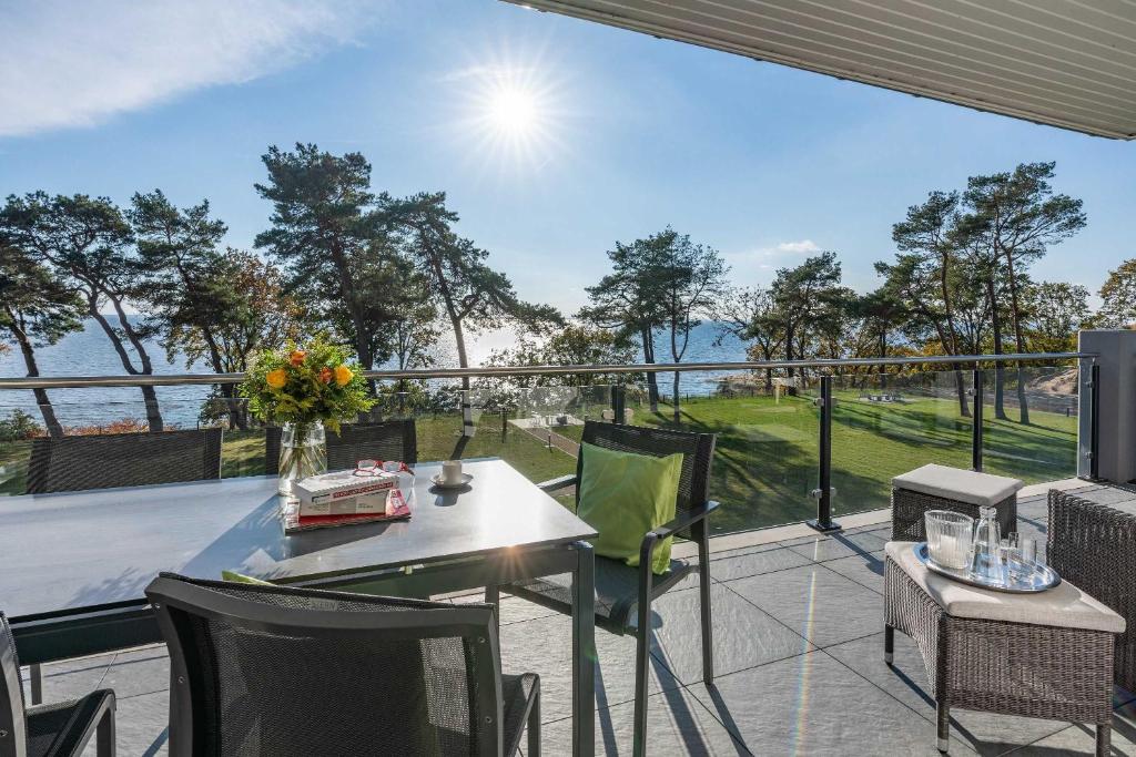 a patio with a table and chairs on a balcony at Appartement "Opal" mit Penthouseflair - Oase am Haff in Garz