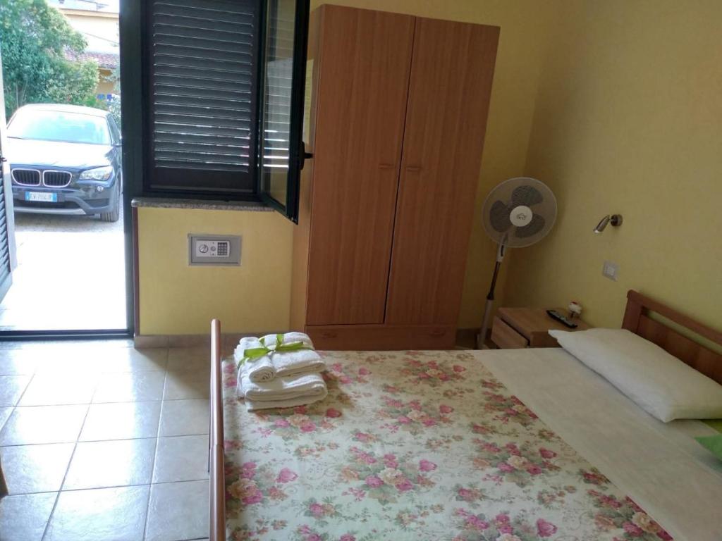 a bedroom with a bed and a fan and a window at B&B Josefine in Marina di Camerota