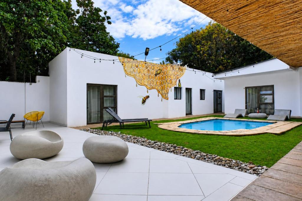 a courtyard with a swimming pool and a house at Hunni Hotel Melrose Edge in Johannesburg