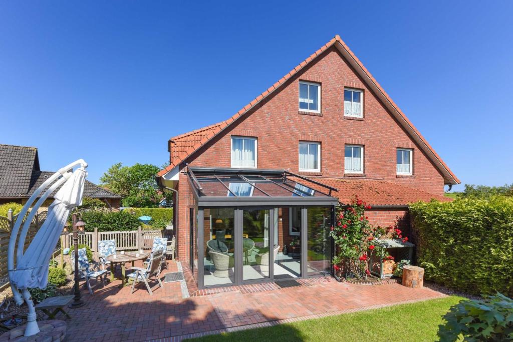 an extension to a house with a conservatory at Ferienhaeuser Deichkrone in Bensersiel