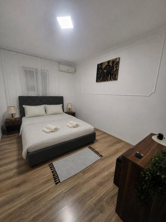 a bedroom with a bed and a wooden floor at Prenociste Simke 2 in Subotica